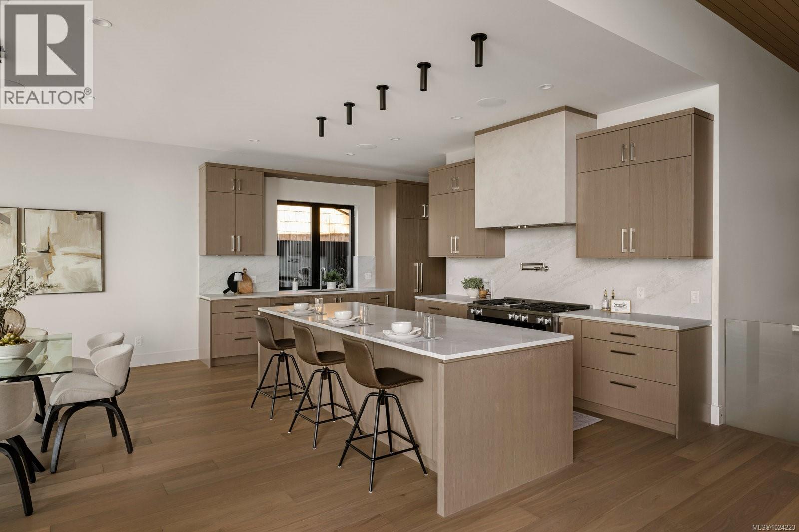 Modern gourmet kitchen with white quartz countertops, stainless steel appliances and large center island