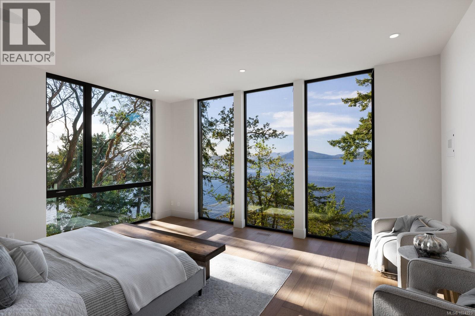 Elegant primary bedroom suite with natural light streaming through windows, overlooking a private garden