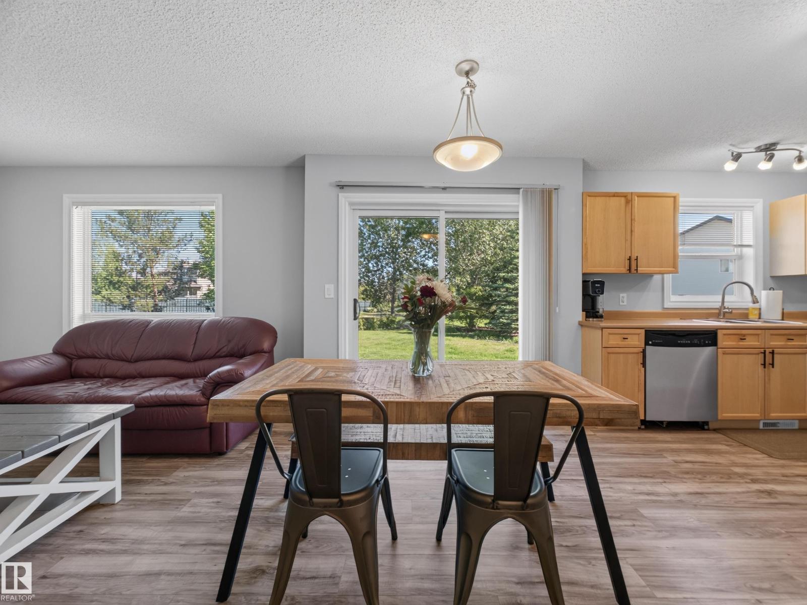 Dining table and living room with the kitchen beyond