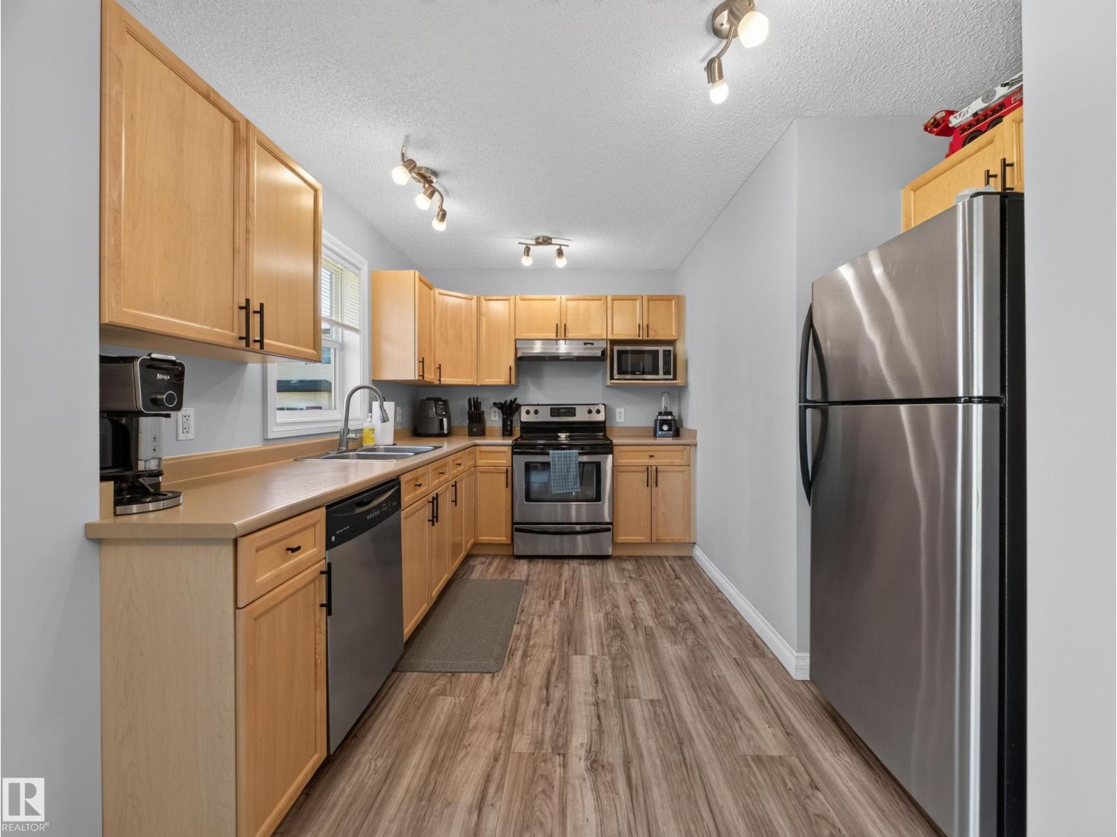 Kitchen with stainless fridge, range, dishwasher and maple cabinets