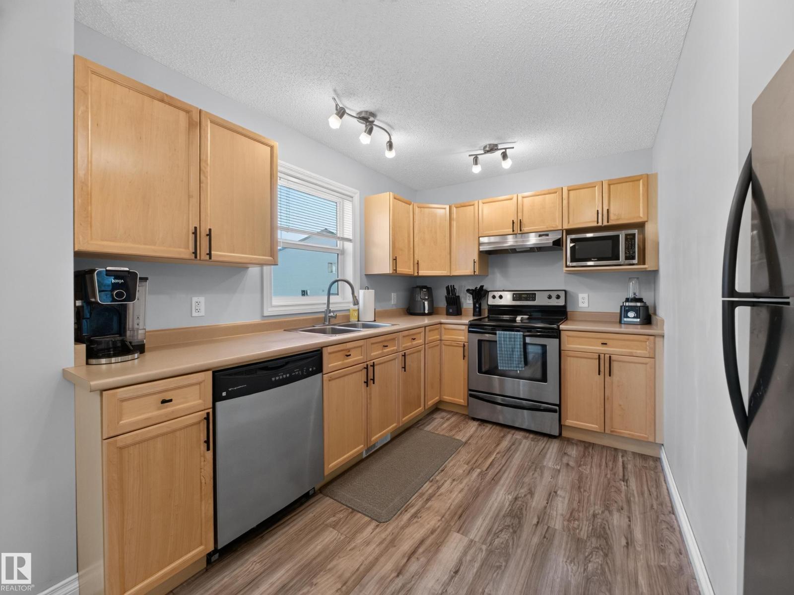 Kitchen with L-shaped counters and track lighting