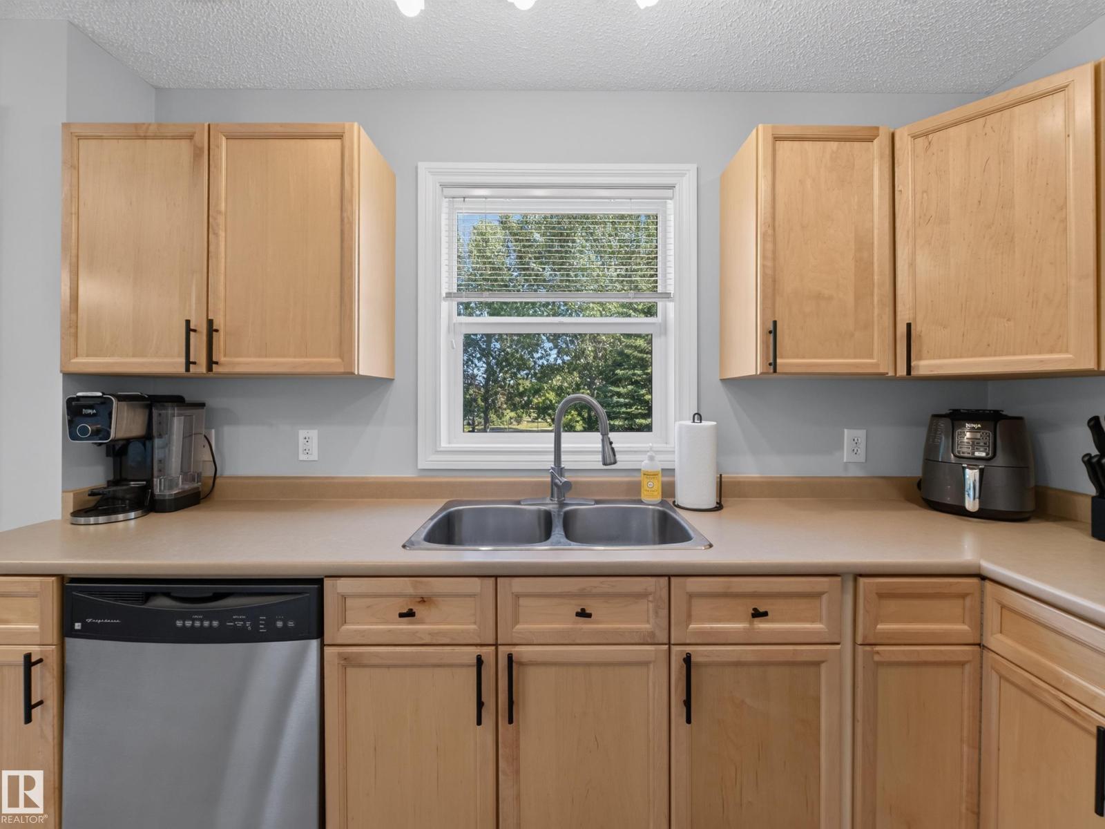 Kitchen sink with the window above and dishwasher
