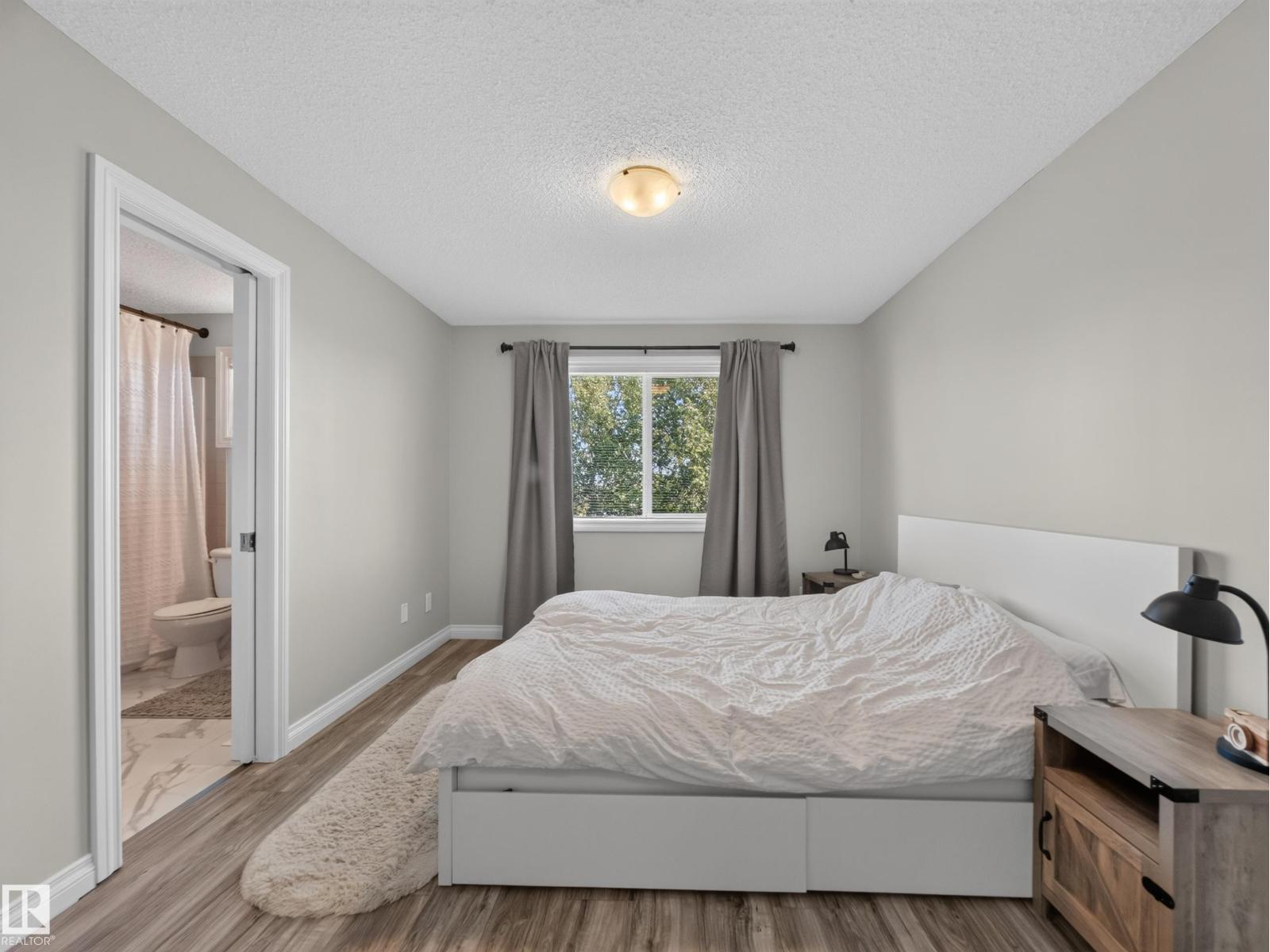 Primary bedroom with bed, window and ensuite door