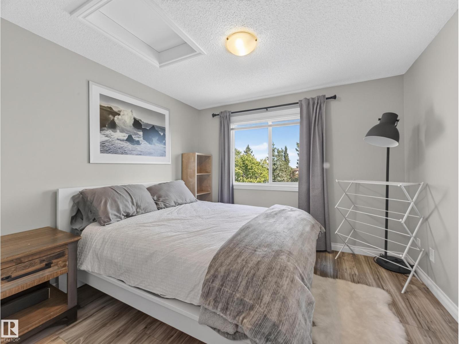 Primary bedroom with bed, nightstand and window
