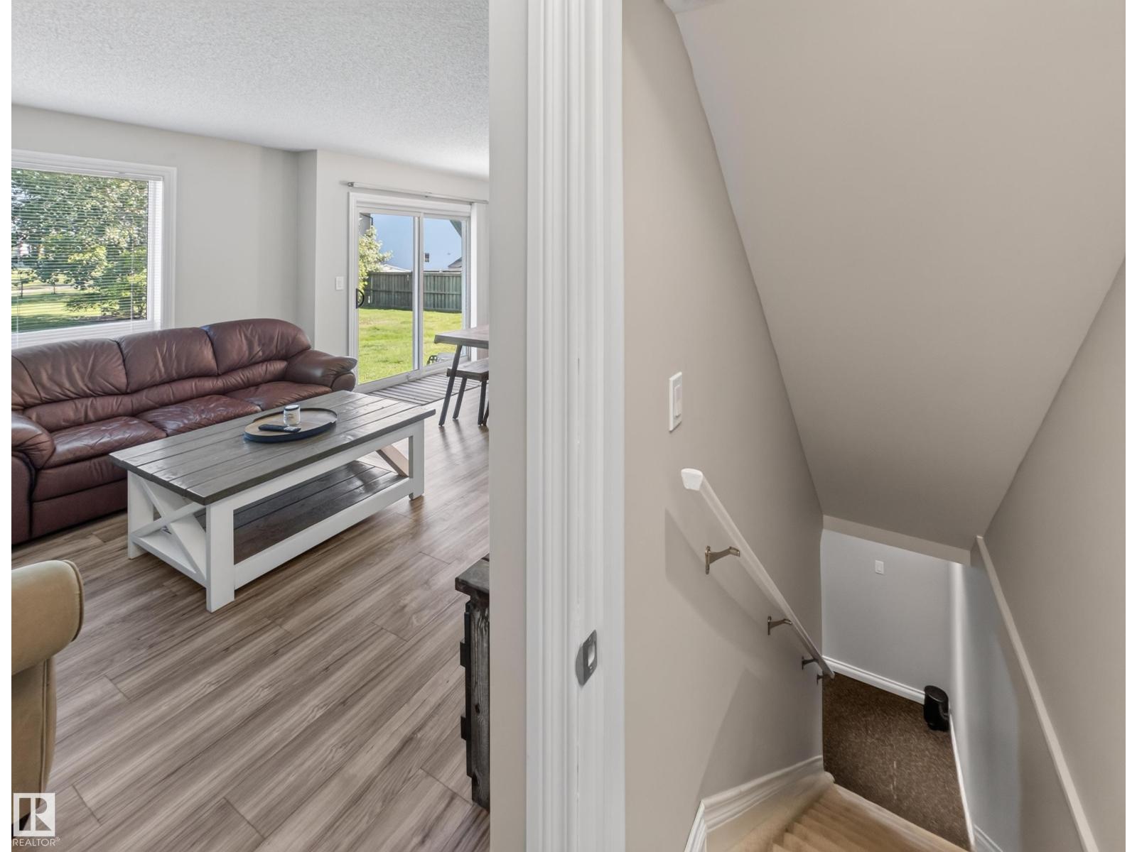 Stairs down to the basement with the living room beyond