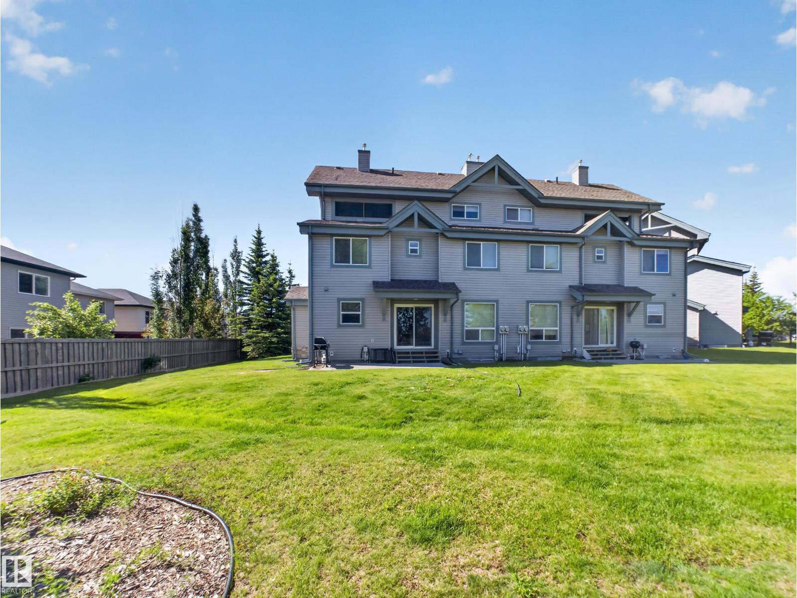 Rear elevation of the row with the wide lawn and fence
