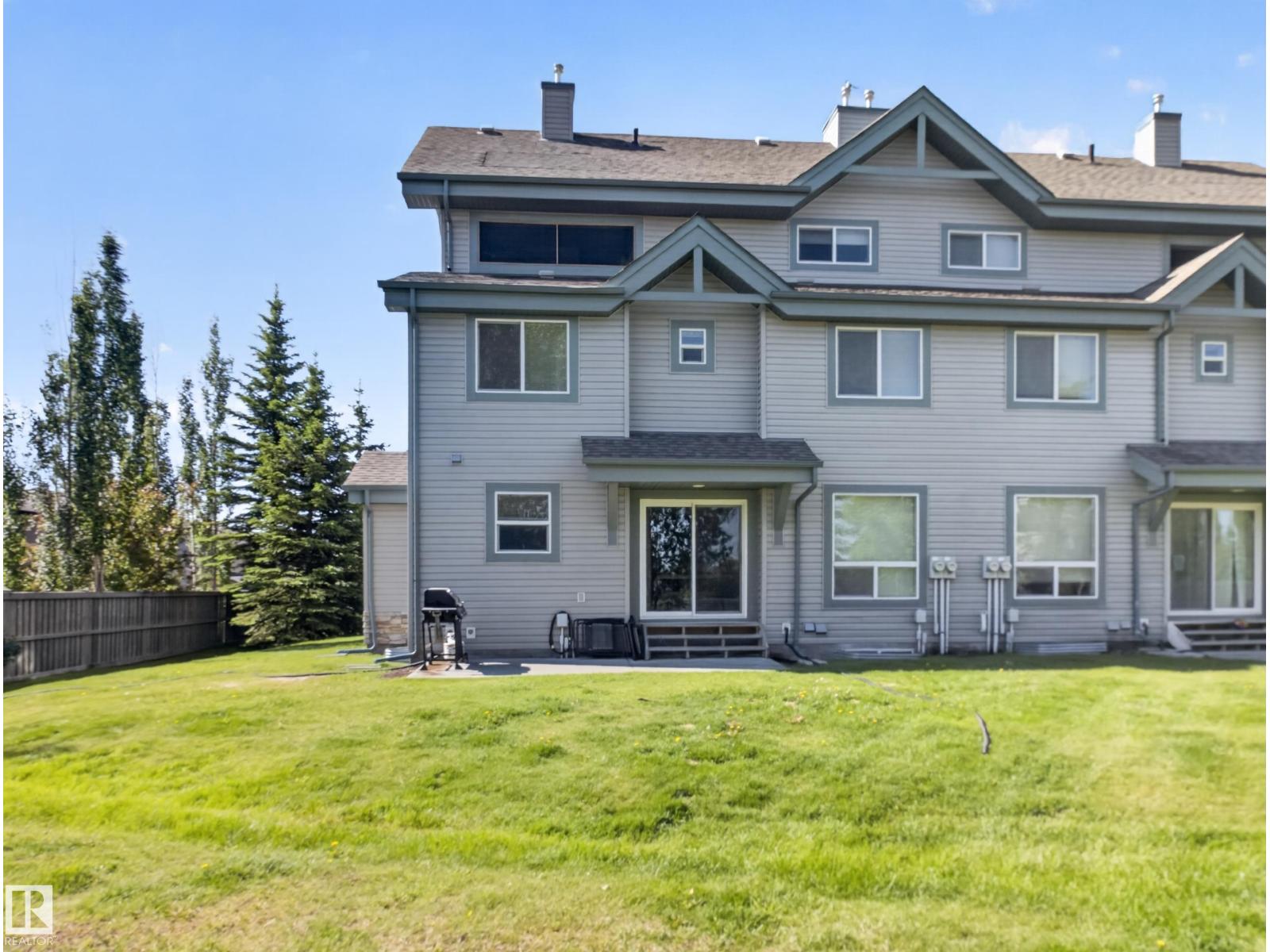 Rear elevation of #44 12050 17 AV SW across the back lawn